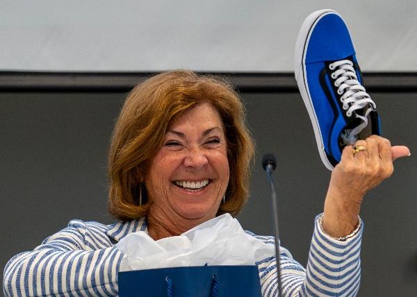 Outgoing GVSU Board Chair Susan Jandernoa smiles as she holds up a commemorative sneaker given as a gift for concluding her two years of service as chair. 